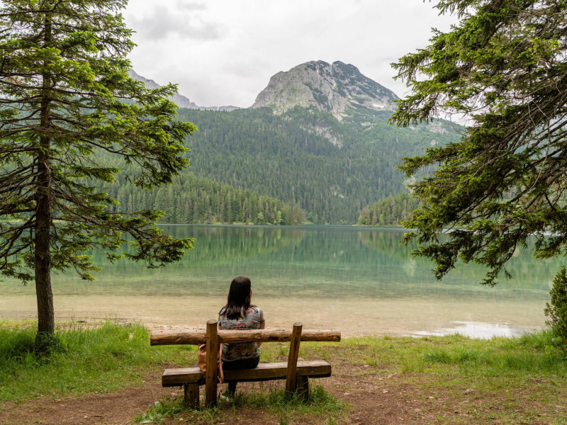 Frau sitzt auf einer holzbank im nationalpark durmitor montenegro 2